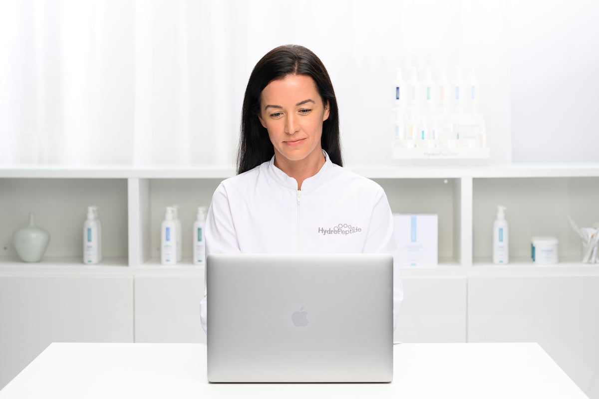 HydroPeptide-specialist bakom laptop – hitta närmaste institut